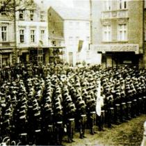 Fotos z filmu "Kolberg" na Rynku Maślanym przed wieża Mikołaja. Na przełomie kwietnia i maja 1944 roku część zdjęć plenerowych do tego filmu była kręcona w Szczecinku. Widzimy grupę statystów, w mundurach żołnierzy piechoty pruskiej z roku 1807